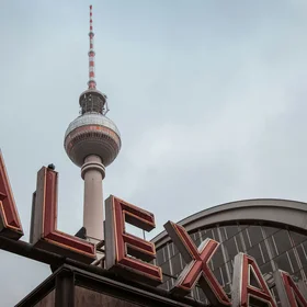 Ihr Stadthotel in Berlin: DASEYN | Fischerinsel Fernsehturm Berlin hinter dem Alex Schriftzug bei bewölktem Himmel