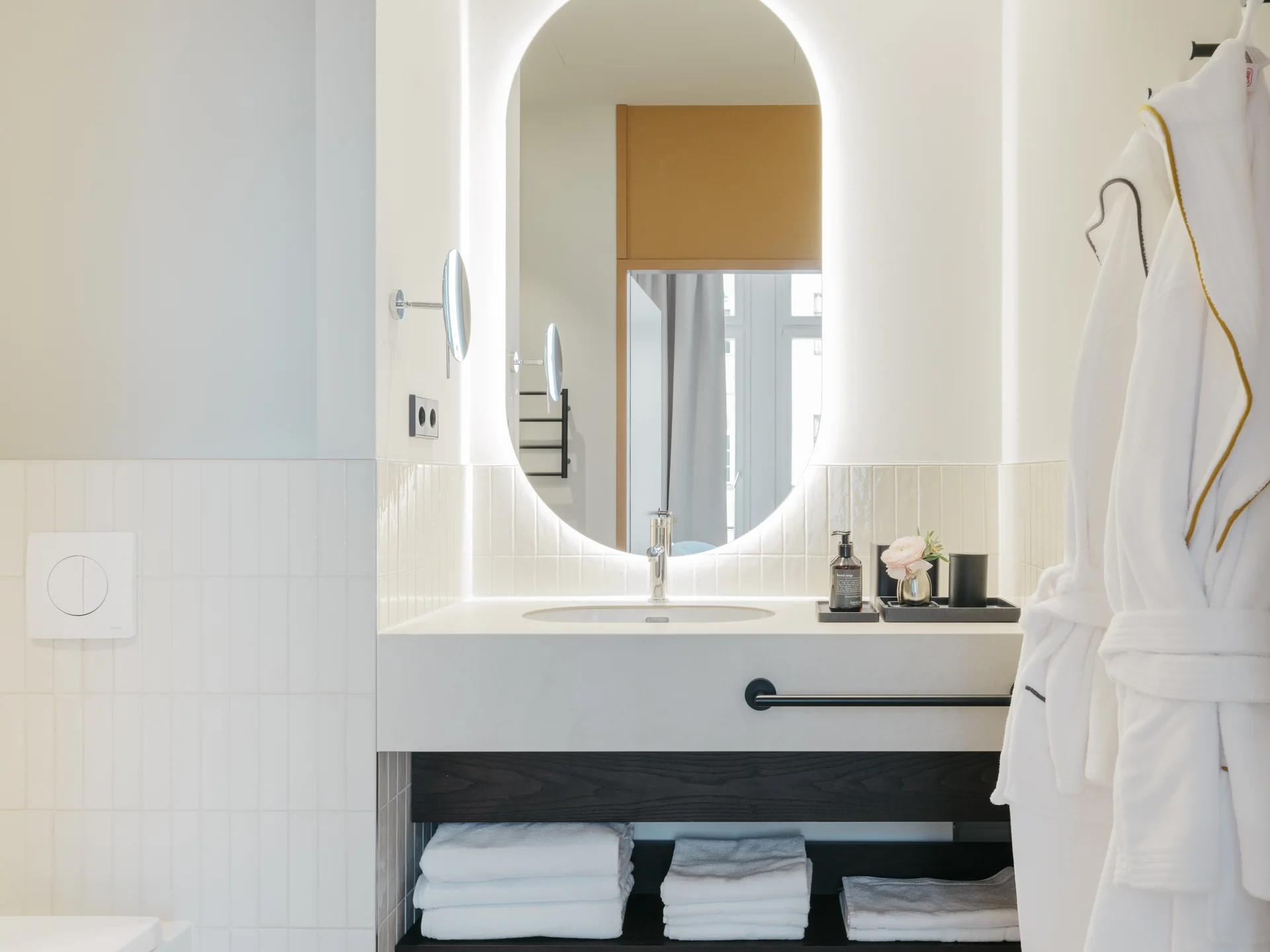 Ihr Stadthotel in Berlin: DASEYN | Fischerinsel Modernes Badezimmer mit rundem beleuchtetem Spiegel und flauschigen Bademänteln